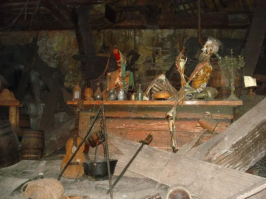 Esqueleto sobre una mesa antigua con objetos desordenados en Piratas del Caribe - Escena macabra y misteriosa